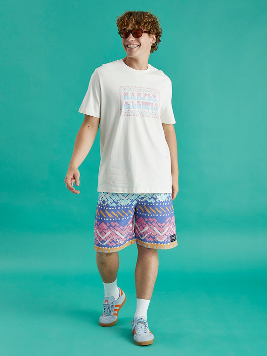 Male model wearing the Taran tee in cream, this tee features a big front chest graphic.