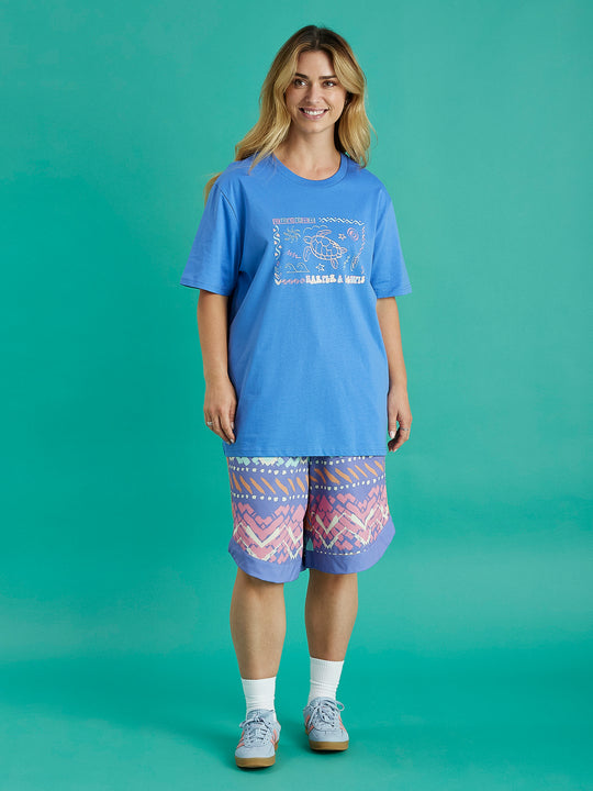 Female model wearing the Surya tee in Royal Blue, the tshirt has a slightly oversized fit and is made from 100% cotton.