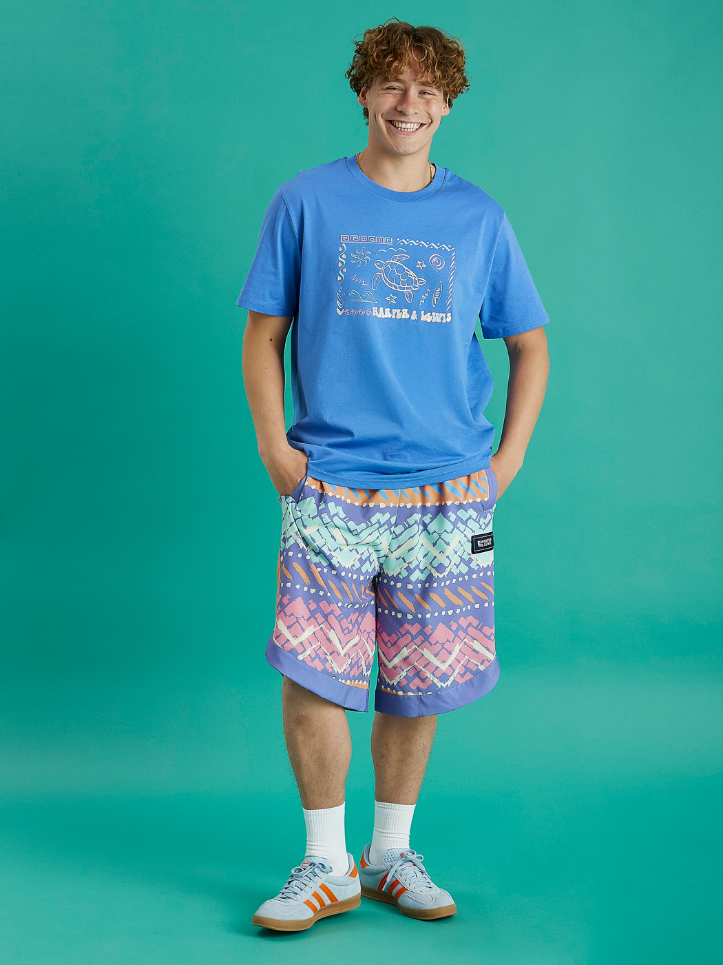 Male model wearing this Royal Blue tshirt casually with some patterned shorts.