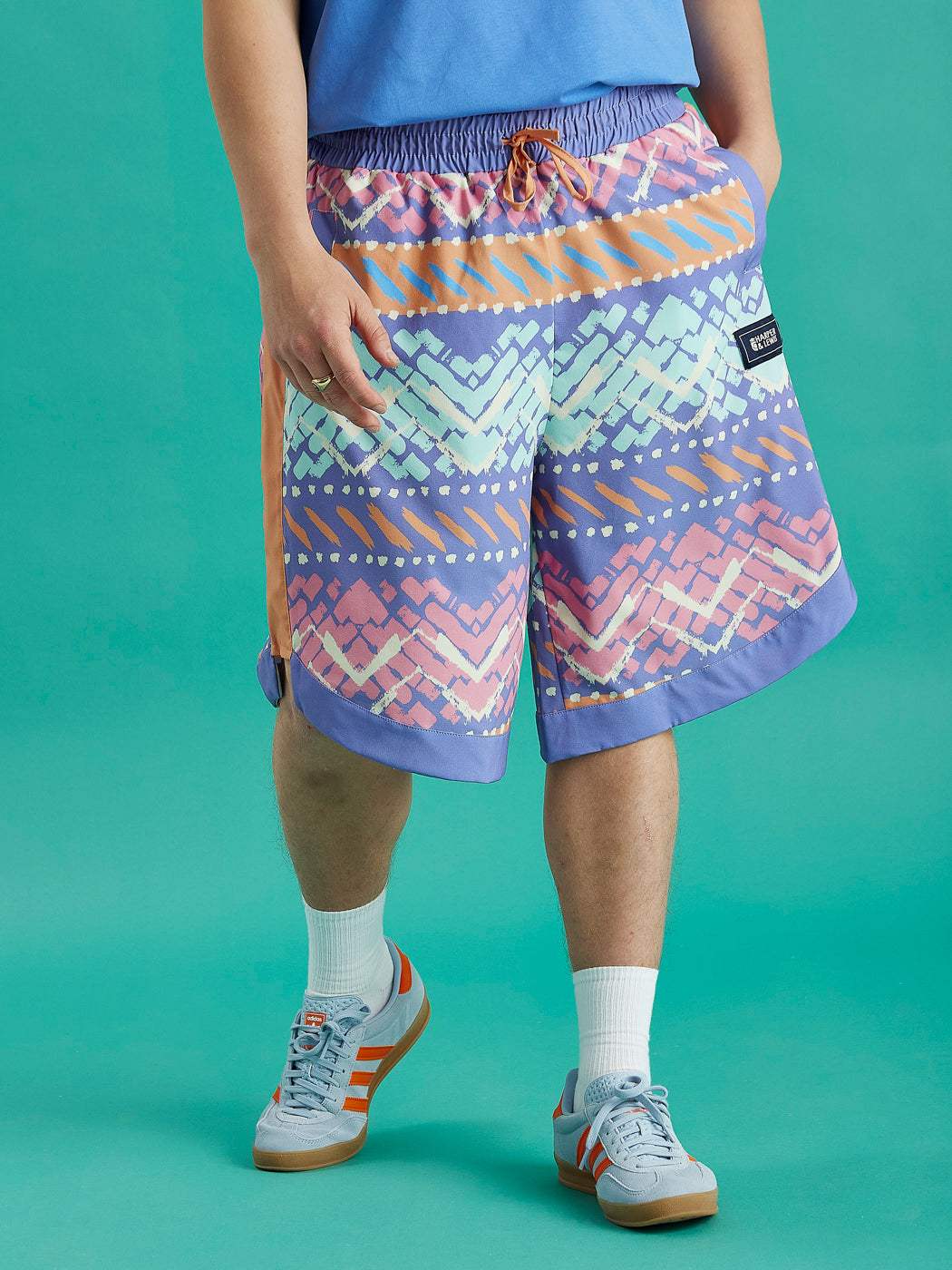 Male Model wearing our Jett shorts which are in an aztec like pattern.