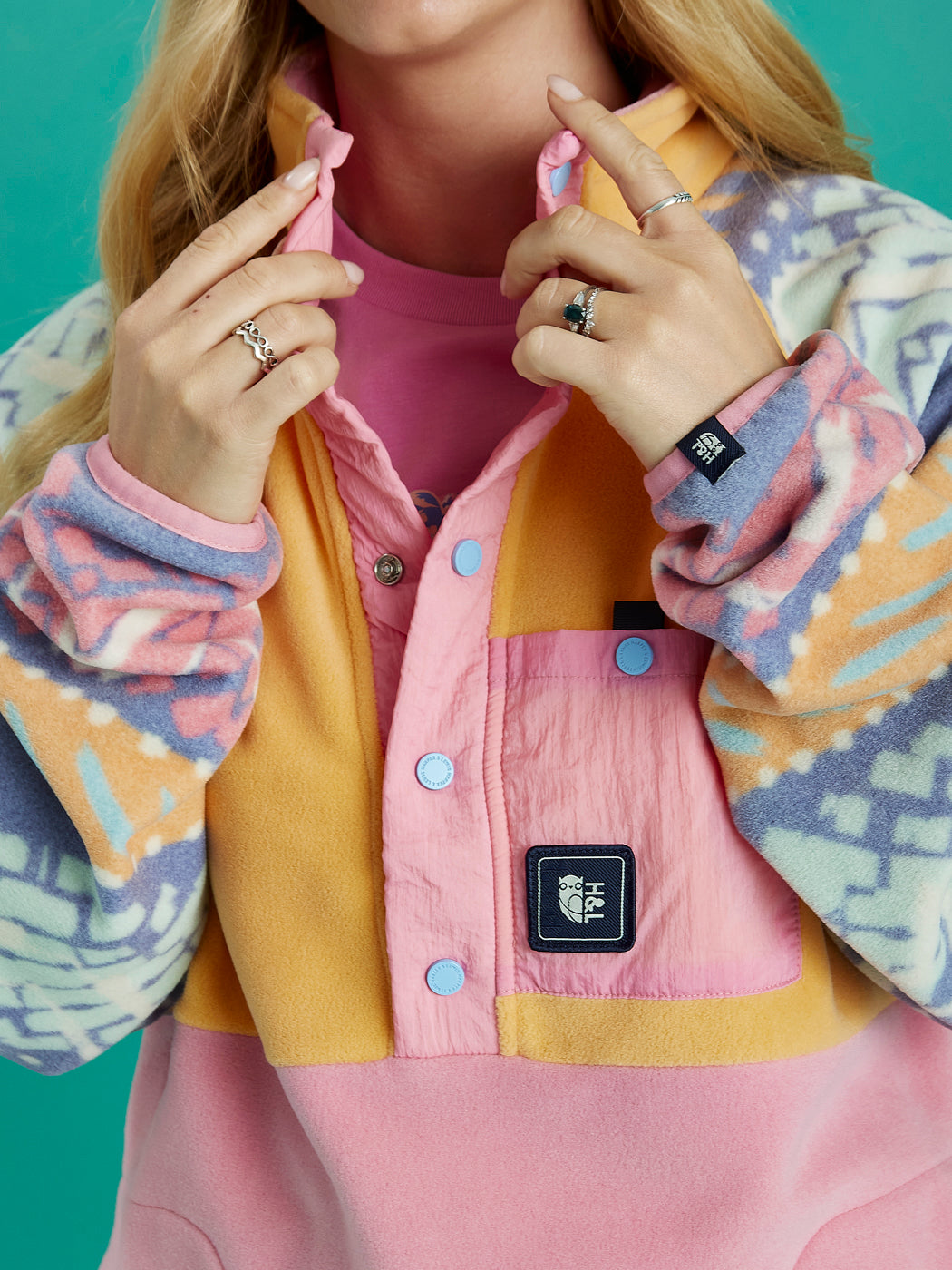 Close up of the details, this features a badge on the front crinkle pocket and a badge on the cuff.