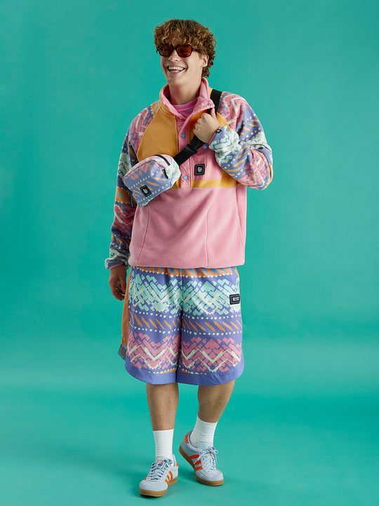 Male Model dressed in a pink fleece jacket and shorts, emphasizing the cozy material of the jacket in a relaxed setting.