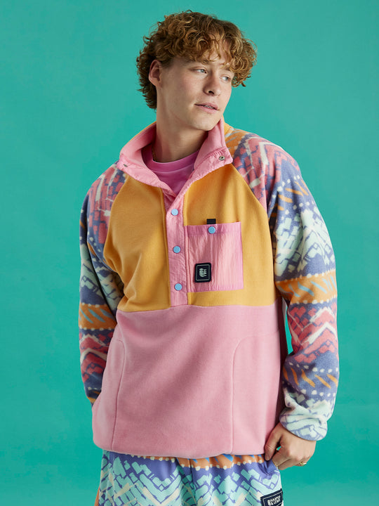Male model wearing the Sutton fleece, with the festival pattern arms, apricot upper and pink details.