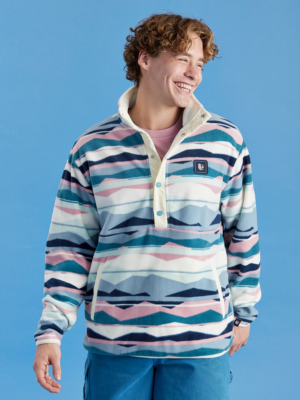 Male Model wearing the Tallow Retro Pattern 1/4 Zip Fleece with navy woven branded details all throughout.