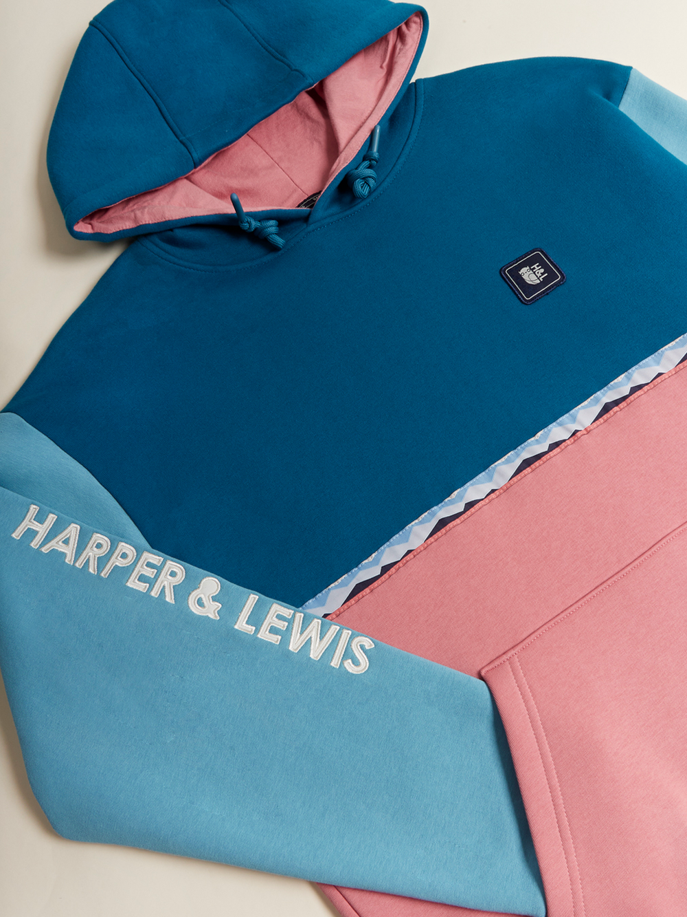 The hoodie features Teal Green, Dusty Pink, and Steel Blue for a striking look.