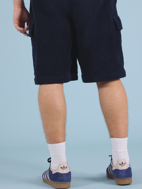 Navy branded woven tab and a branded woven badge on the left leg. 